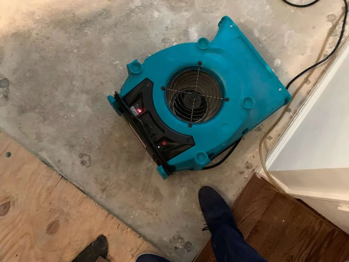 Air mover drying subfloor during Commercial Water Damage Restoration in Millburn